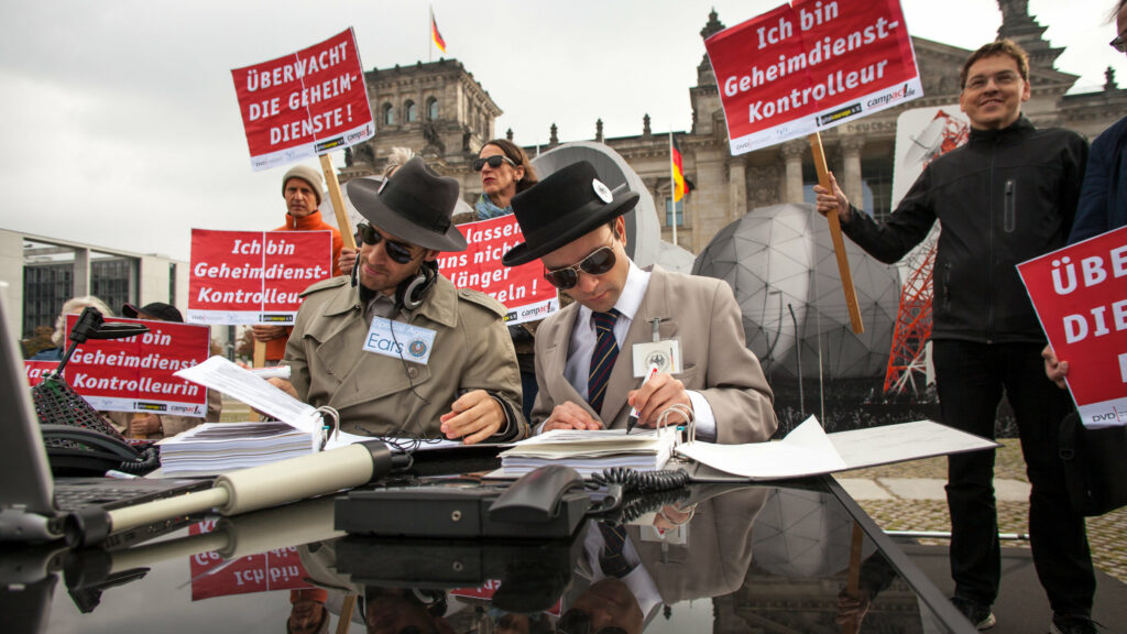 Trenchcoat, Sonnenbrille, Hut: Zugegeben, unsere vermeintlichen Schnüffler sahen schon sehr klischeehaft aus. So konnten sie aber gut zeigen, was der amerikanische Geheimdienst NSA mit Duldung der Bundesregierung tut – uns Bürger*innen nach Belieben aushorchen.