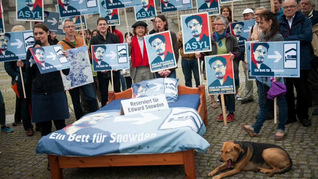 Ein Bett für Edward Snowden: 2013 hatte der Whistleblower aufgedeckt, dass wir Bürger*innen im großen Stil ausspioniert werden. Mit unserem aufgestellten Schlafplatz zeigten wir der Bundesregierung, dass es für diesen Dienst politisches Asyl geben muss.