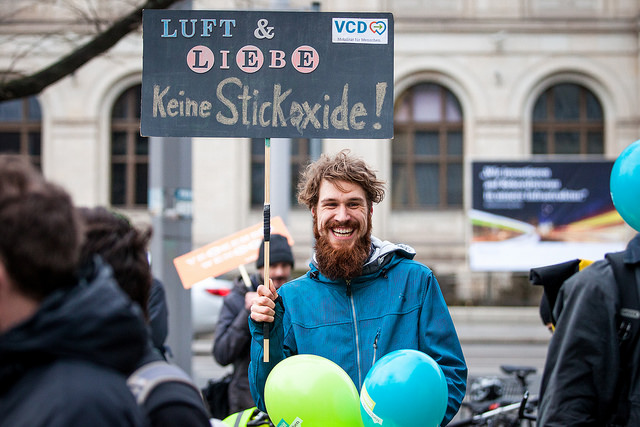 Mann hält Schild mit Aufschrift: Luft & Liebe - keine Stickoxide!