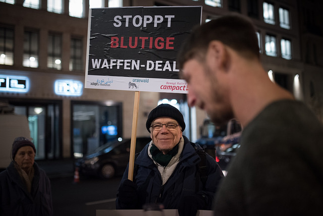 Mann hält campact-Schild: Stoppt blutige Waffen-Deals