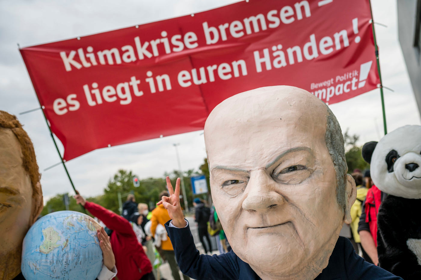 Campact protestiert mit einer Pappmaché-Figur von Kanzler Olaf Scholz (SPD) für Klimaschutz