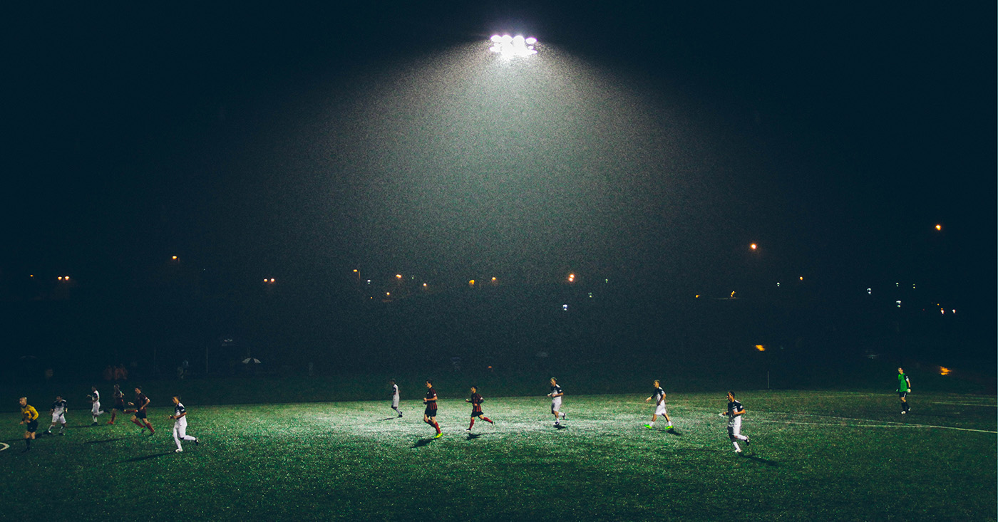 Fußballer*innen bei Nacht auf dem Fußballfeld