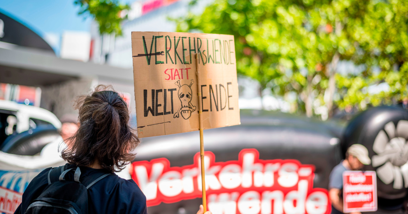 Eine Person hält ein Plakat in die Höhe, Verkehrswende statt Weltende steht darauf.