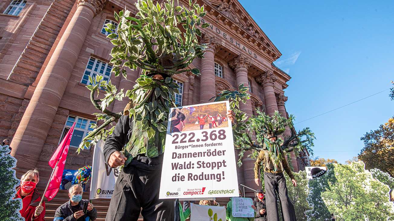 Unterstützer*innen von Campact, BUND und Greenpeace demonstrieren vor dem Landeshaus in Wiesbaden für den Erhalt des Dannenröder Waldes.
