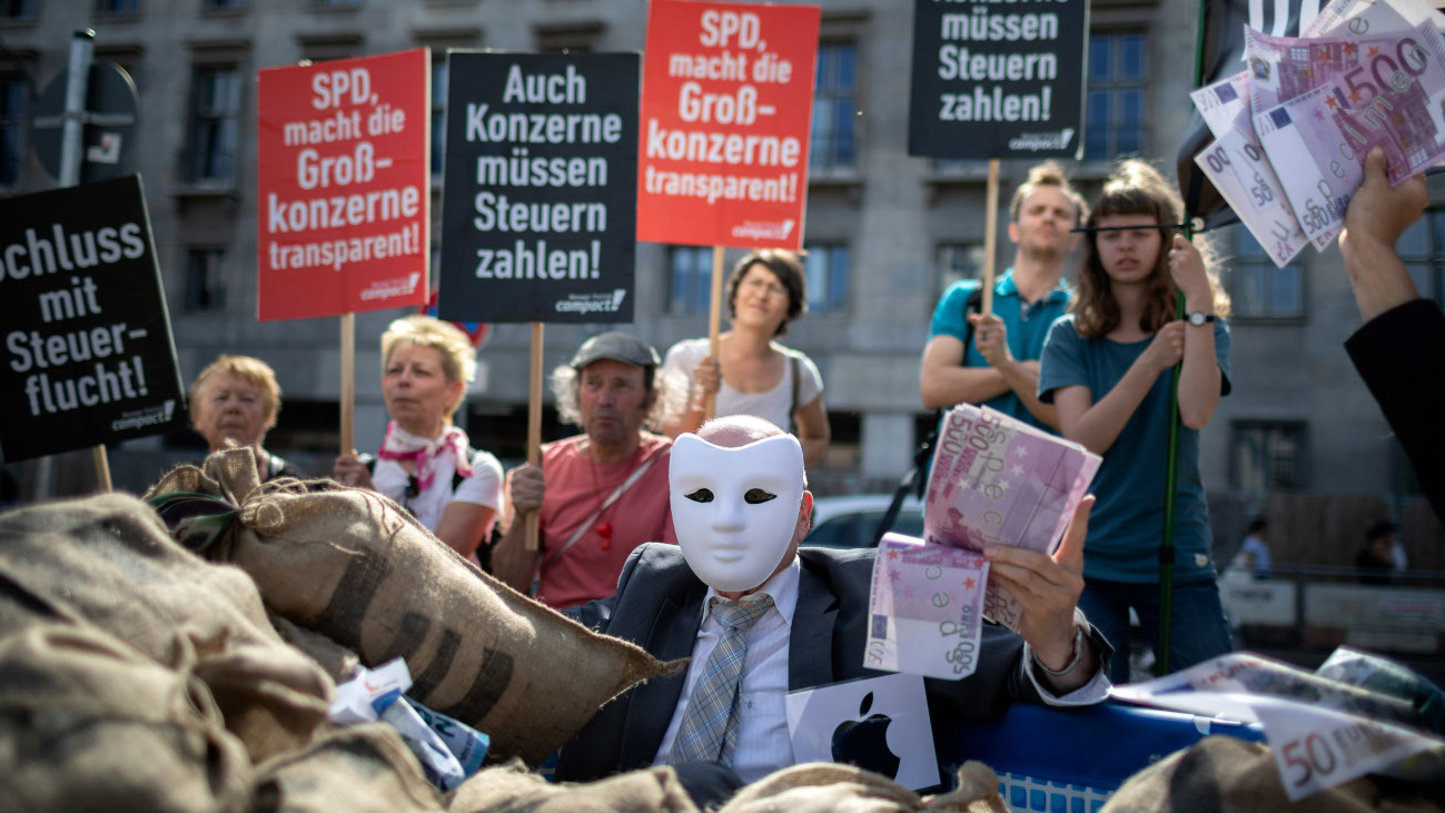 Mann Mit Maske hält bei einer Kundgebung mehrere 500-Euro-Scheine in der Hand