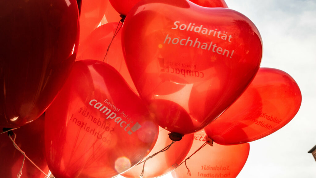 Solidarität hochhalten! Bedruckte Luftballons in Herzform von Campact beim solidarischen Herbst.