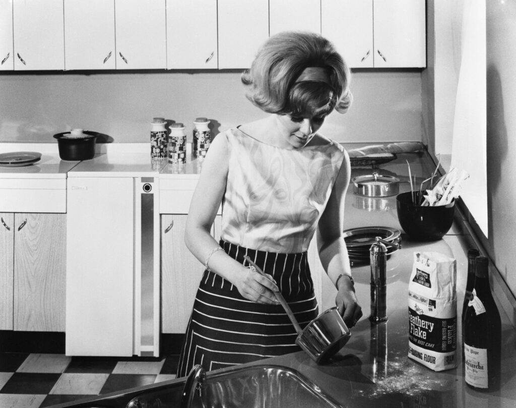 Schwarzweißbild einer Frau in der Küche, ca. 1950er Jahre