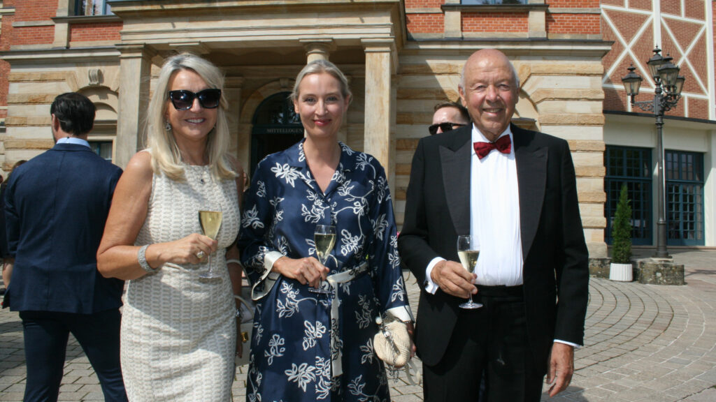 Alice Weidel(AfD) - in der Mitte- zusammen mit Unternehmer Theo Mueller (Mueller Milch), und seiner Frau Beate Ebert beim Besuch der Vorstellung von "Die Walkuere" bei den Bayreuther Festspielen 2025 mit Sekt in der Hand.