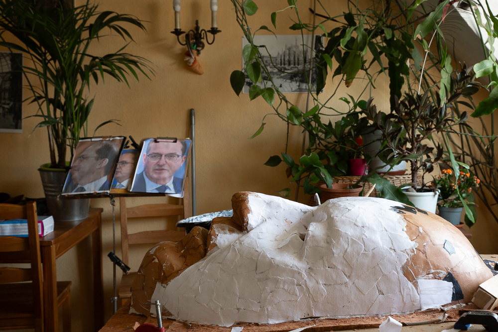 Damit die Maske dem Politiker ähnlich sieht, hat Elmar Harz Porträtfotos neben seinem Arbeitsplatz aufgestellt, die er immer wieder mit der Maske abgleicht.