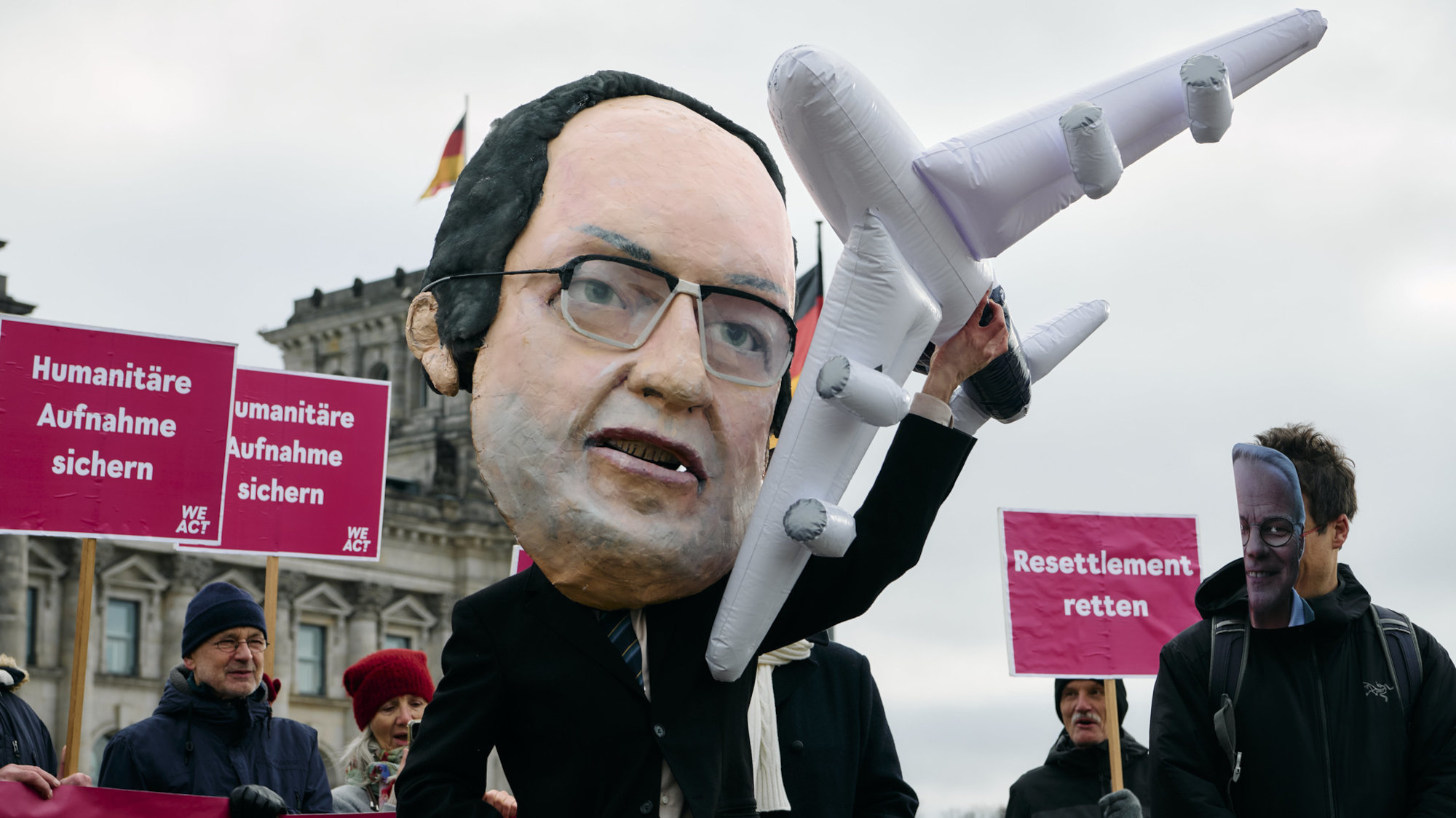 Die fertige Maske im Einsatz vor dem Reichstag, bei einer Aktion von WeAct, der Petitionsplattform von Campact. Die Initiator*innen einer Petition fordern den Innenminister auf, Einreisezusagen für schutzbedürftige Flüchtende einzuhalten.