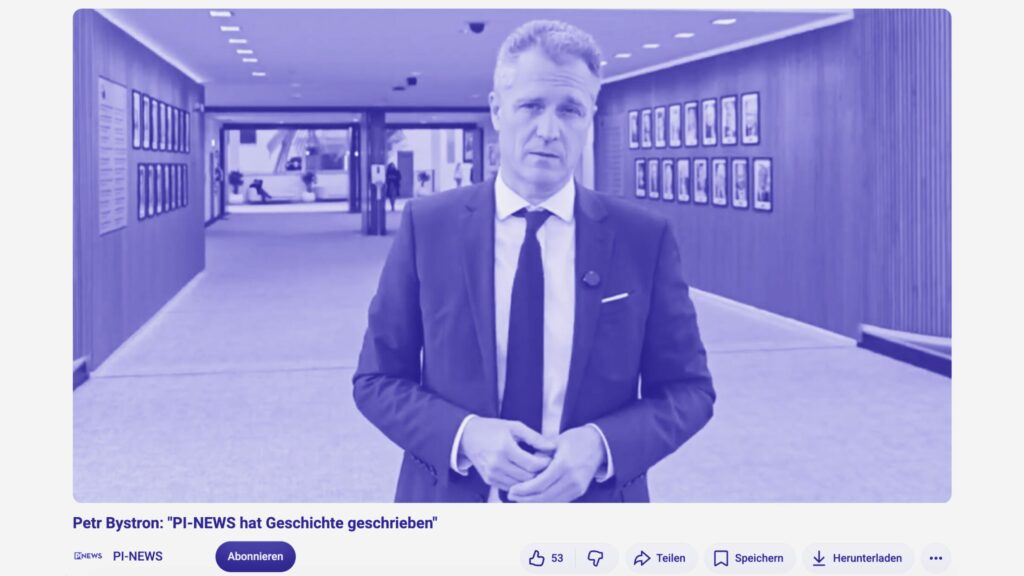 Screenshot aus einem Video, in dem Petr Bystron auf dem Gang des Bundestages eine Grußbotschaft für PI News spricht. Er blickt in die Kamera und ist bekleidet mit einem blauen Anzug.